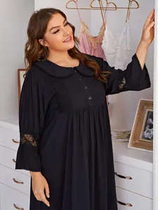 Plus size long sleeve black nightdress with lace details shown in a cozy home setting