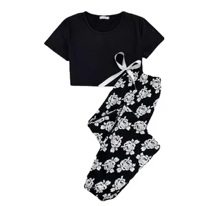 Two-piece women's summer pajama set with black short sleeve crop top and floral pants