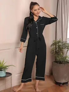 Detailed view of women's black long-sleeve jumpsuit pajama with white piping