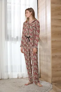 Elegant woman wearing red leopard print long-sleeved pajama set in a cozy home setting