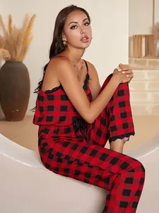 Full view of red and black buffalo plaid pajama set worn by model in a minimalist setting