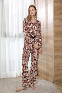 Full-length detail view of leopard print women's two-piece pajama set with black bow tie belt