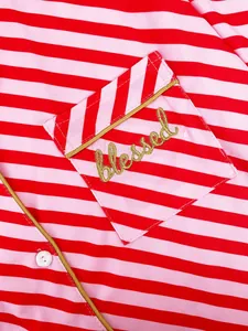 Close-up of red and pink striped pajamas with gold "blessed" embroidery on pocket.