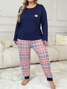 Plus size two-piece pajama set with heart print top and plaid pants in cozy home setting