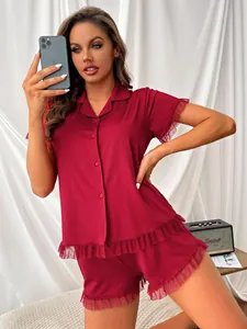 Detail view of a burgundy short-sleeved pajama set featuring delicate mesh ruffle edges