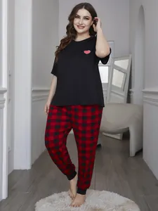 Full detail of plus size women's pajama set featuring a heart print top and plaid pants