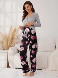 Full view of long-sleeved grey pajama top and floral pants in cozy home setting