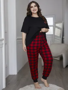 Plus size women's pajama set featuring black heart t-shirt and red plaid pants.