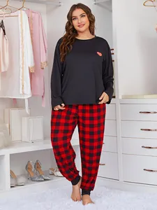 Plus size women's pajama set featuring black heart print top and red plaid pants