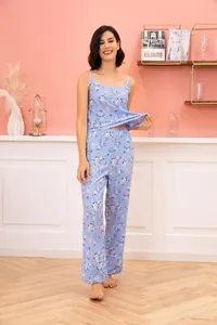 Floral blue camisole and long pajama pants set worn by model in a cozy room