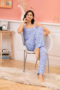 Detail view of blue floral camisole and pants pajamas set in a cozy home setting