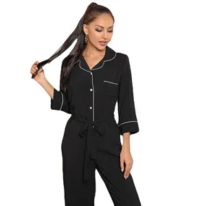 Women's black long sleeve jumpsuit pajamas with white piping and waist tie