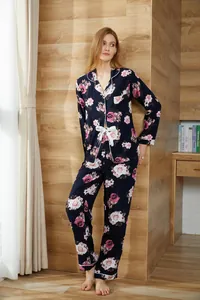 Two-piece floral pajamas for women with long-sleeved button-up shirt and navy blue trousers.