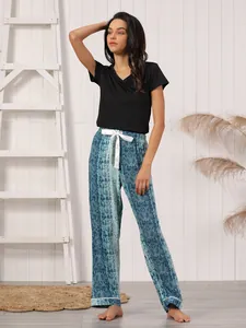 Detail view of women's two-piece pajamas featuring black short sleeve top and snake print pants