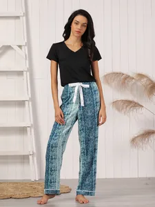 Woman in black V-neck t-shirt and blue snake print pajama pants with white bow