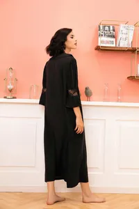 Elegant black Victorian style nightgown with delicate lace sleeves in a cozy room.