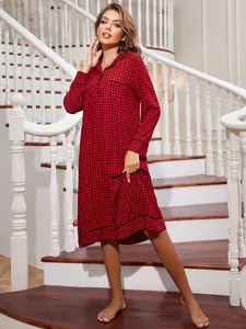 Women's red and black plaid long-sleeved nightgown shown on a model on stairs.