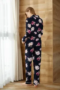Back view of floral navy blue long-sleeve pajama set for women in cozy room