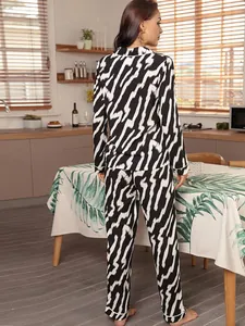 Back view of a woman wearing black and white zebra print pajama set in a cozy kitchen setting