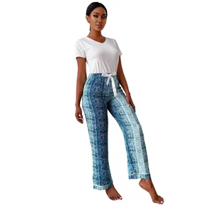 Full-length view of woman in white V-neck top and blue snake print pajama pants