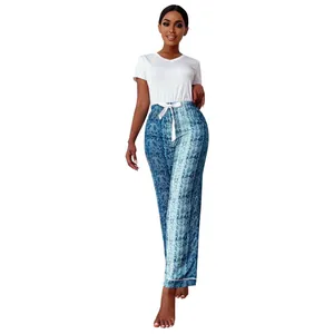 Detail view of women's two-piece pajama set with white top and snake print pants