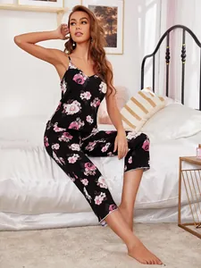 Professional detail shot of black floral camisole pajama set worn by model on white bed