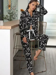 Close-up of elegant black floral long-sleeve pajama set for women in a cozy home setting