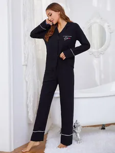 Elegante conjunto de pijama de viscosa negra para mujer con ribetes blancos y solapa