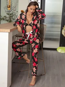 Model wearing a black floral long-sleeve pajama set in a stylish kitchen home setting.