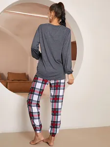 Vista posteriore di un set pigiama donna con maglia grigia e pantaloni a quadri scozzesi