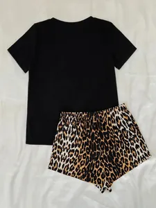 Platliggende weergave van een tweedelige pyjamaset met een zwart t-shirt en luipaardshort.