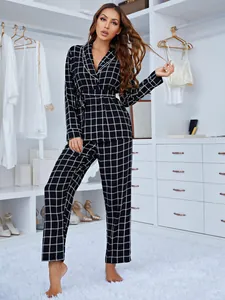 Vue en pied d'un pyjama à carreaux noir et blanc avec lien à la taille dans un dressing