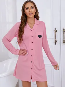 Détail d'une chemise de nuit rose à manches longues pour femme avec motif de cœur