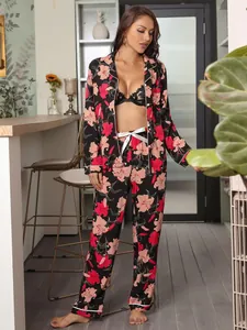 Full body view of a woman wearing a black floral pajama set in a cozy home setting.