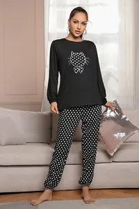 Completo da casa due pezzi donna con maglia gatto cartoon e pantaloni a pois neri.