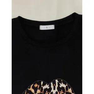Close-up van zwart dames pyjamashirt met luipaardprint en label met maat S erop
