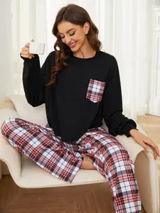 Lifestyle view of a woman in a black top and plaid pajama set relaxing on an armchair.