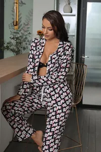 Full view of floral print long-sleeved pajama set worn by model in a modern room