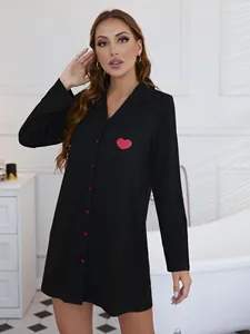 Gros plan d'une chemise de nuit noire à manches longues avec un cœur rouge sur la poche