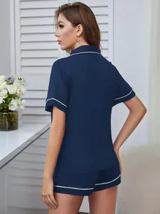 Rückansicht des dunkelblauen Damen-Schlafanzug-Sets mit eleganten weißen Paspeln.