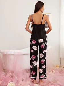Back view of elegant women's black camisole and pink floral print pajama pants set.