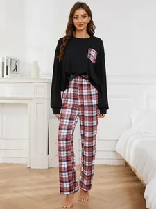 Detailed view of women's two-piece pajama set with black top and plaid pants.