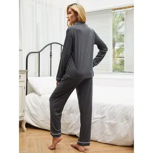 Elegant dark gray two-piece women's pajama set featuring white piping and soft long sleeves
