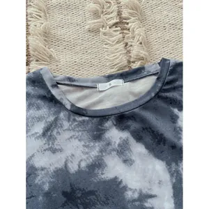 Close-up of grey and white tie-dye pajama top neckline with size S tag