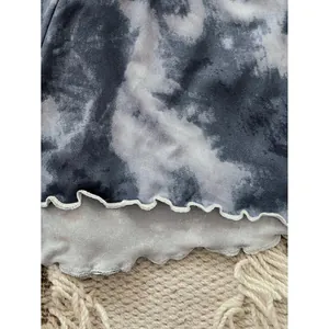 Close-up of tie-dye women's pajama set with ruffled hem and soft fabric texture