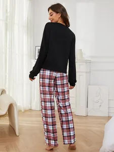 Back view of woman wearing plaid long-sleeve pajama set in cozy home setting