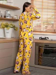 Detail of woman in yellow floral pajama set standing in kitchen