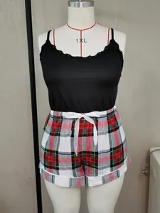 Detailweergave van plus size pyjamaset met zwart kanten hemdje en geruite short op een mannequin