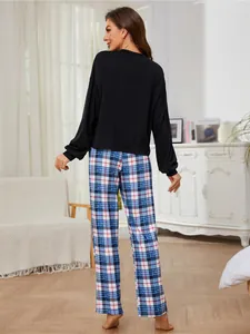 Detailed back view of women's two-piece pajama set with black top and plaid pants