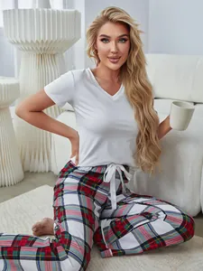 Lifestyle-Detail eines Damen-Pyjama-Sets mit weißem V-Ausschnitt-Oberteil und Karo-Hose.